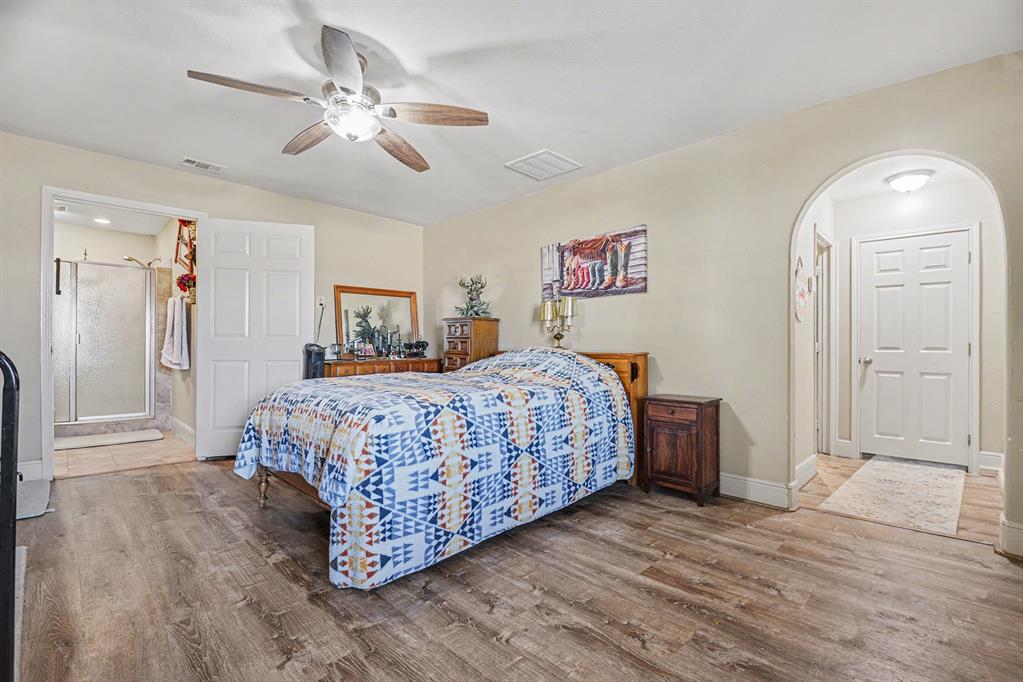2474 McConnell Road Gunter, TX 75058 - Photo 8 of 17 a bedroom with a large bed a chandelier and closet