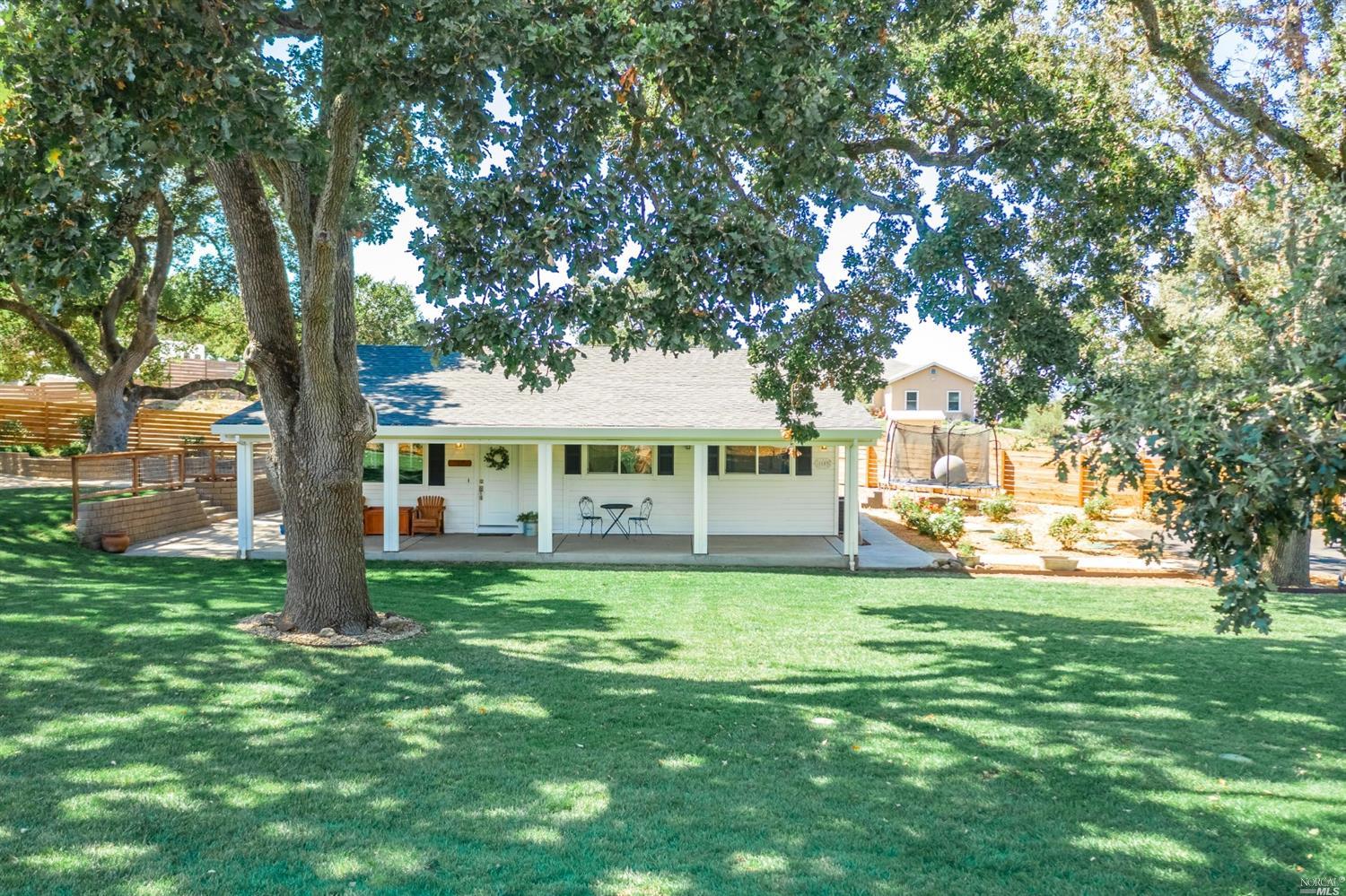 a view of a house with a big yard and large trees