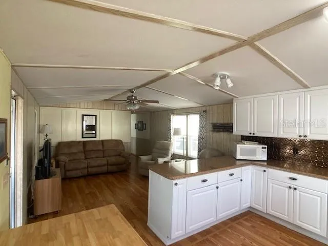 a kitchen with kitchen island granite countertop a refrigerator and wooden cabinets