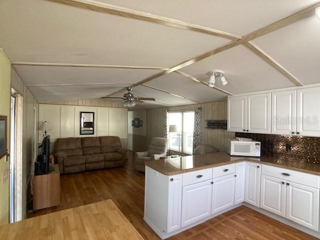 1710 7th Street Southwest, Unit 24 Ruskin, FL 33570 - Photo 13 of 44 a kitchen with kitchen island granite countertop a refrigerator and wooden cabinets