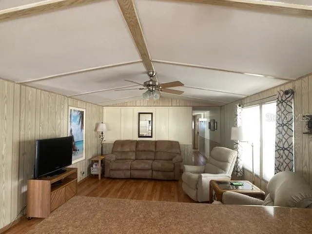 a living room with furniture a flat screen tv and a window