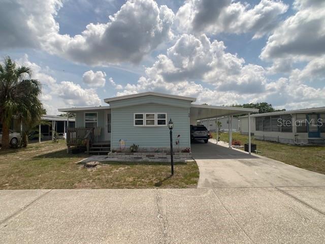 1710 7th Street Southwest, Unit 24 Ruskin, FL 33570 - Photo 2 of 44 a front view of a house with a garden and trees