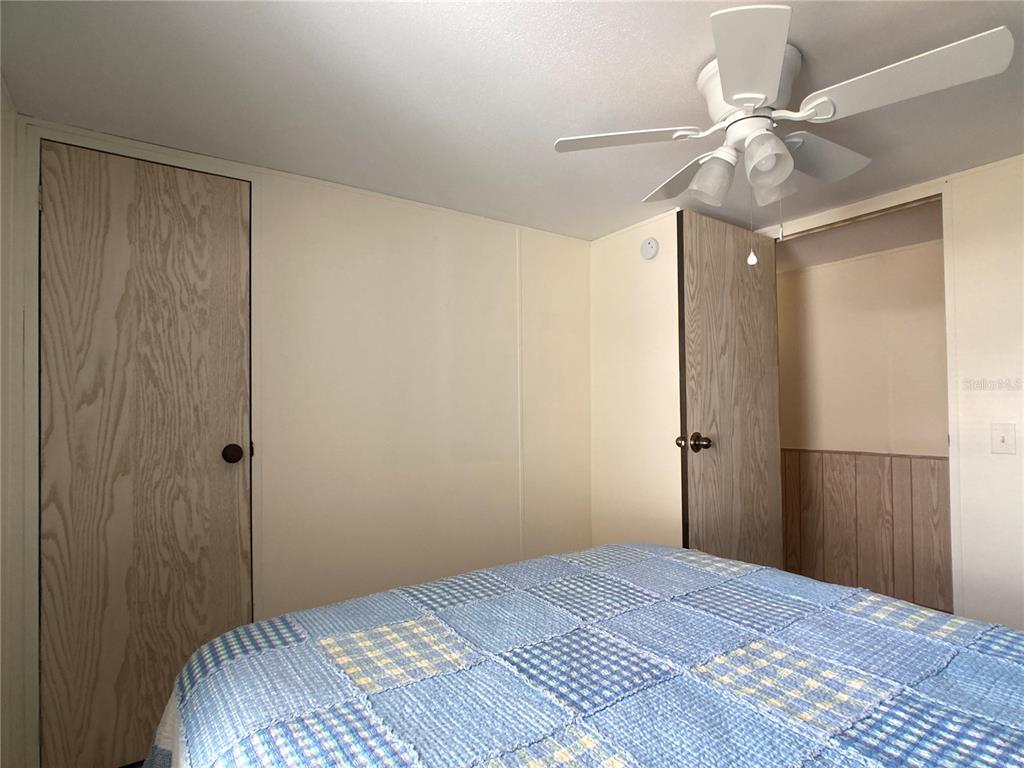 1710 7th Street Southwest, Unit 24 Ruskin, FL 33570 - Photo 29 of 44 a bedroom with a bed and a chandelier