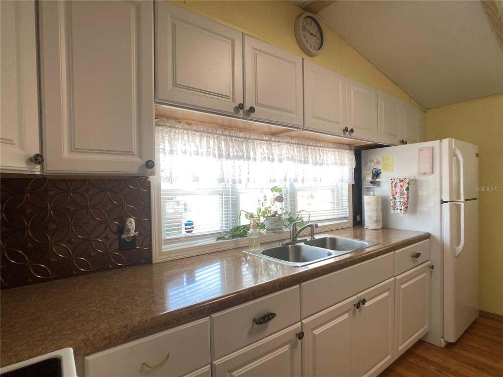 1710 7th Street Southwest, Unit 24 Ruskin, FL 33570 - Photo 9 of 44 a kitchen with stainless steel appliances granite countertop a sink a refrigerator and cabinets with wooden floor