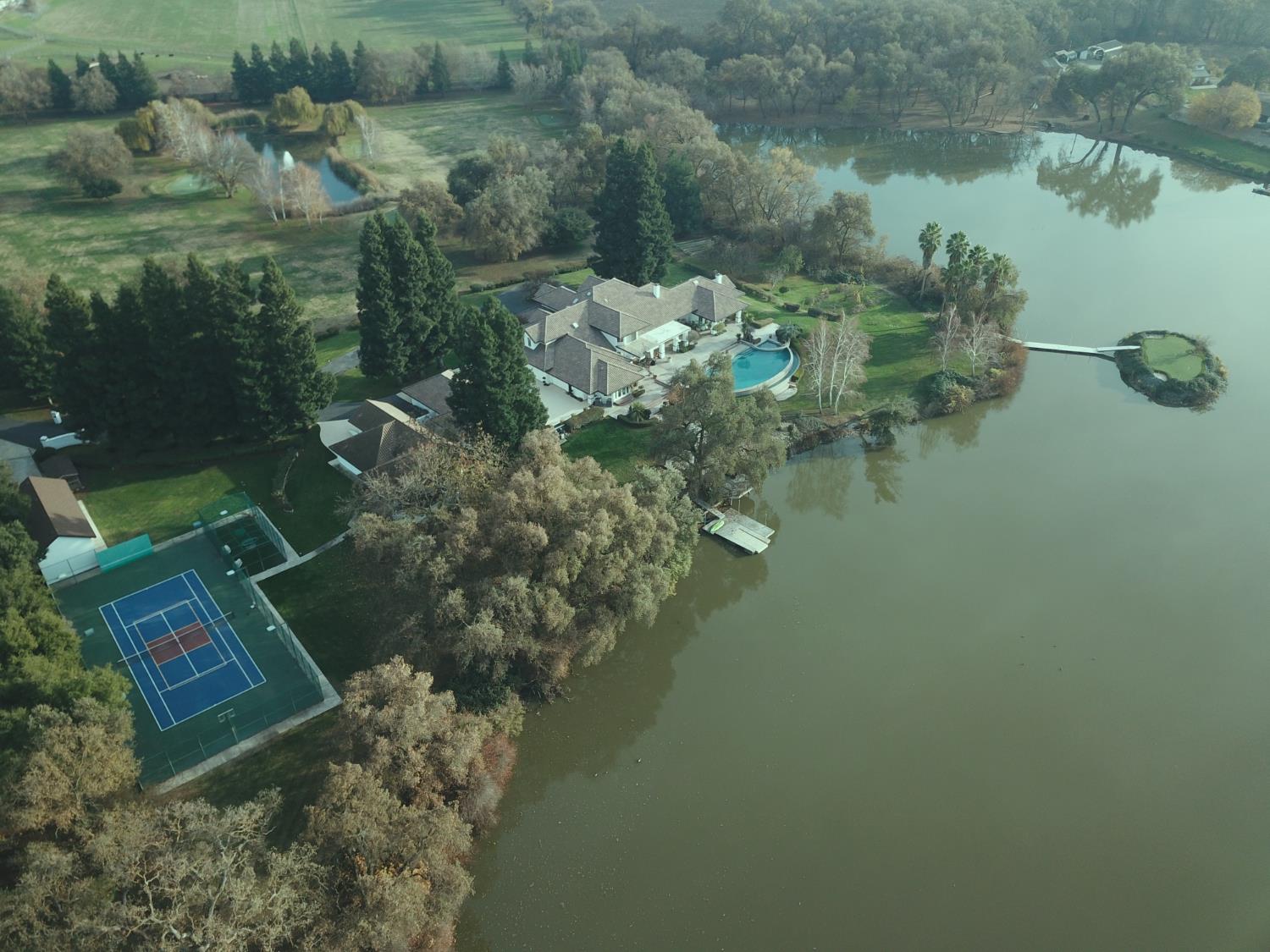 a aerial view of a house with a yard and lake view