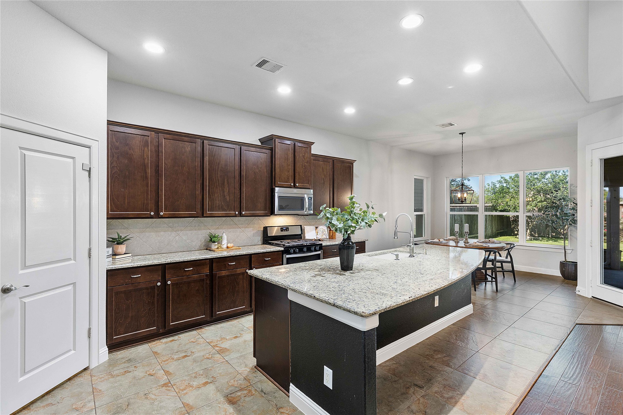 29539 Monona Terrace Court Spring, TX 77386 - Photo 17 of 50 The large kitchen has tons of storage and an oversized pantry. The curve of the granite island keeps the open feel of the space while still providing a bar area to sit at the island. *Staged furniture and accessories do not convey with the home*