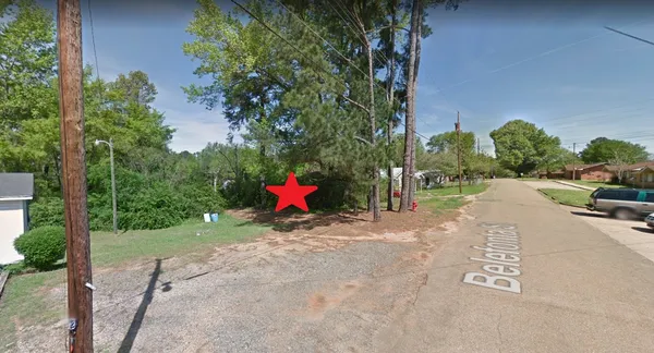 a view of a road with a house in the background