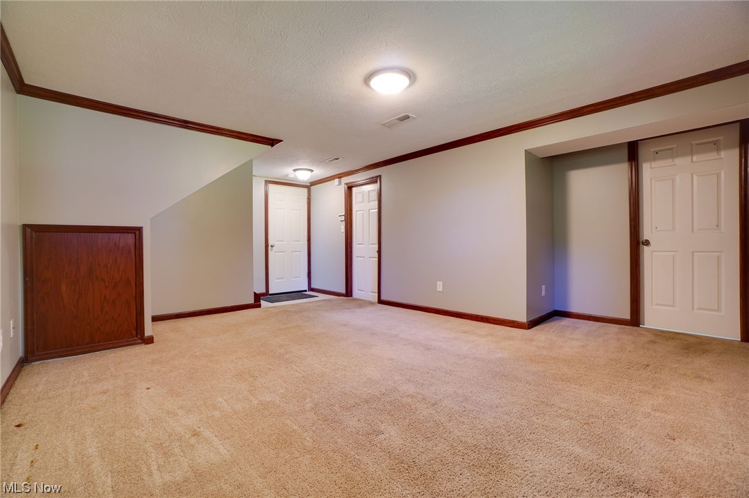 6406 Liberty Road Solon, OH 44139 - Photo 13 of 35 Unfurnished room featuring a textured ceiling, ornamental molding, and light carpet