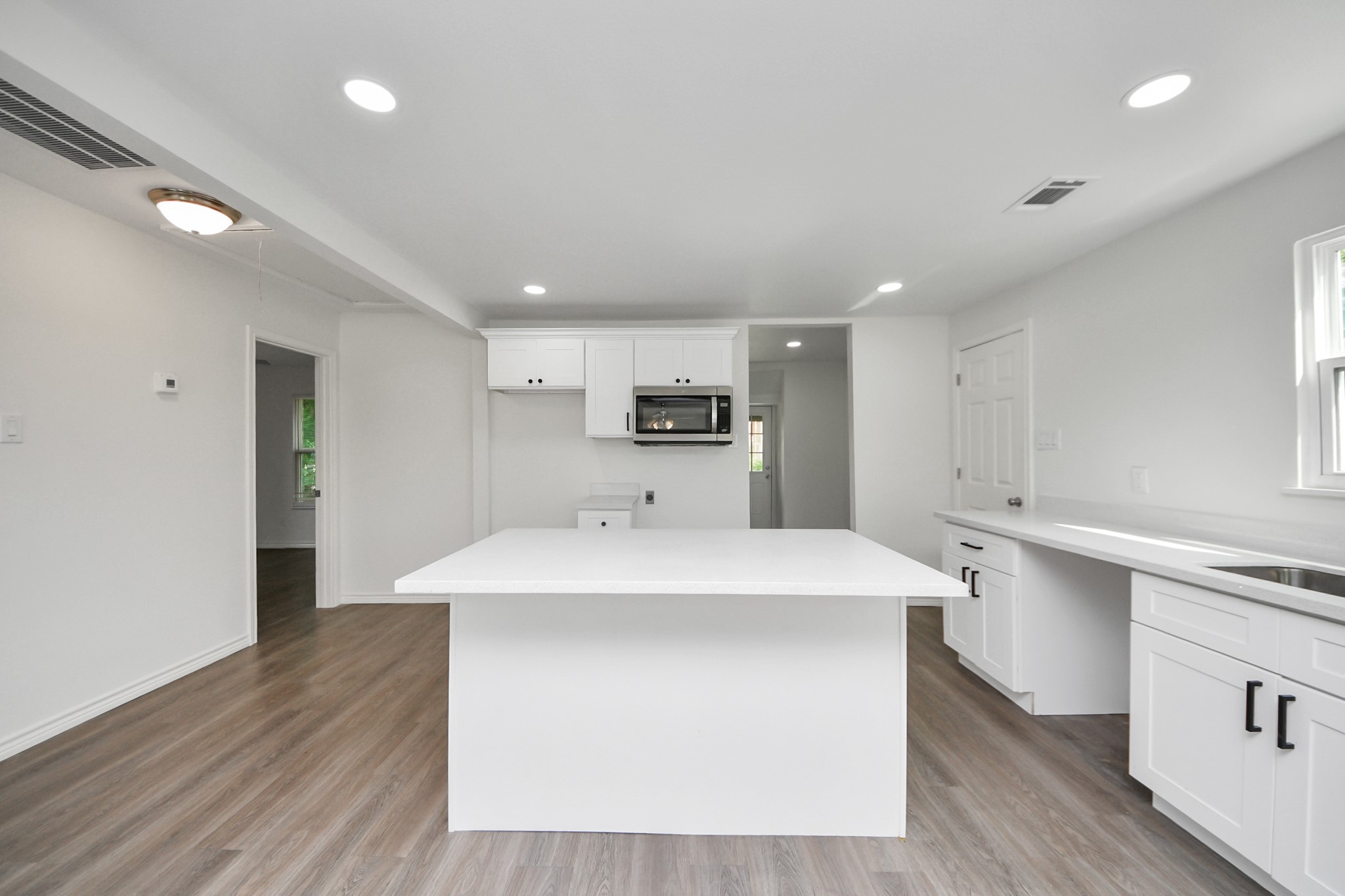 7004 Conley Street Houston, TX 77021 - Photo 23 of 32 a large white kitchen with wooden floor