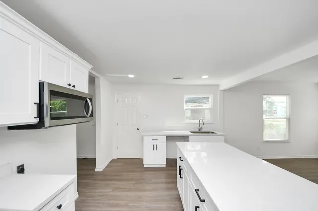 a kitchen with a sink a microwave and cabinets