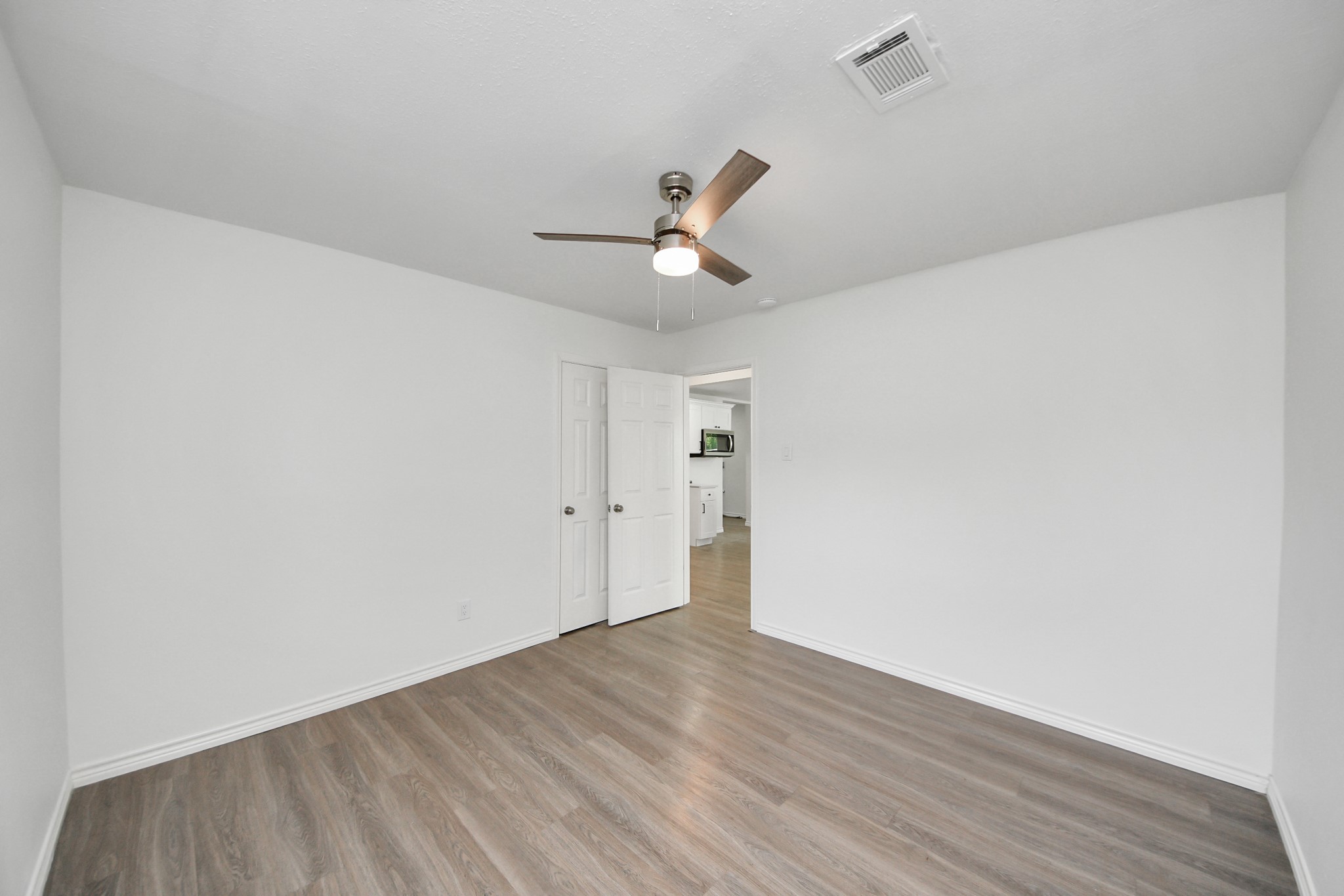 7004 Conley Street Houston, TX 77021 - Photo 26 of 32 a view of a room with wooden floor and a ceiling fan