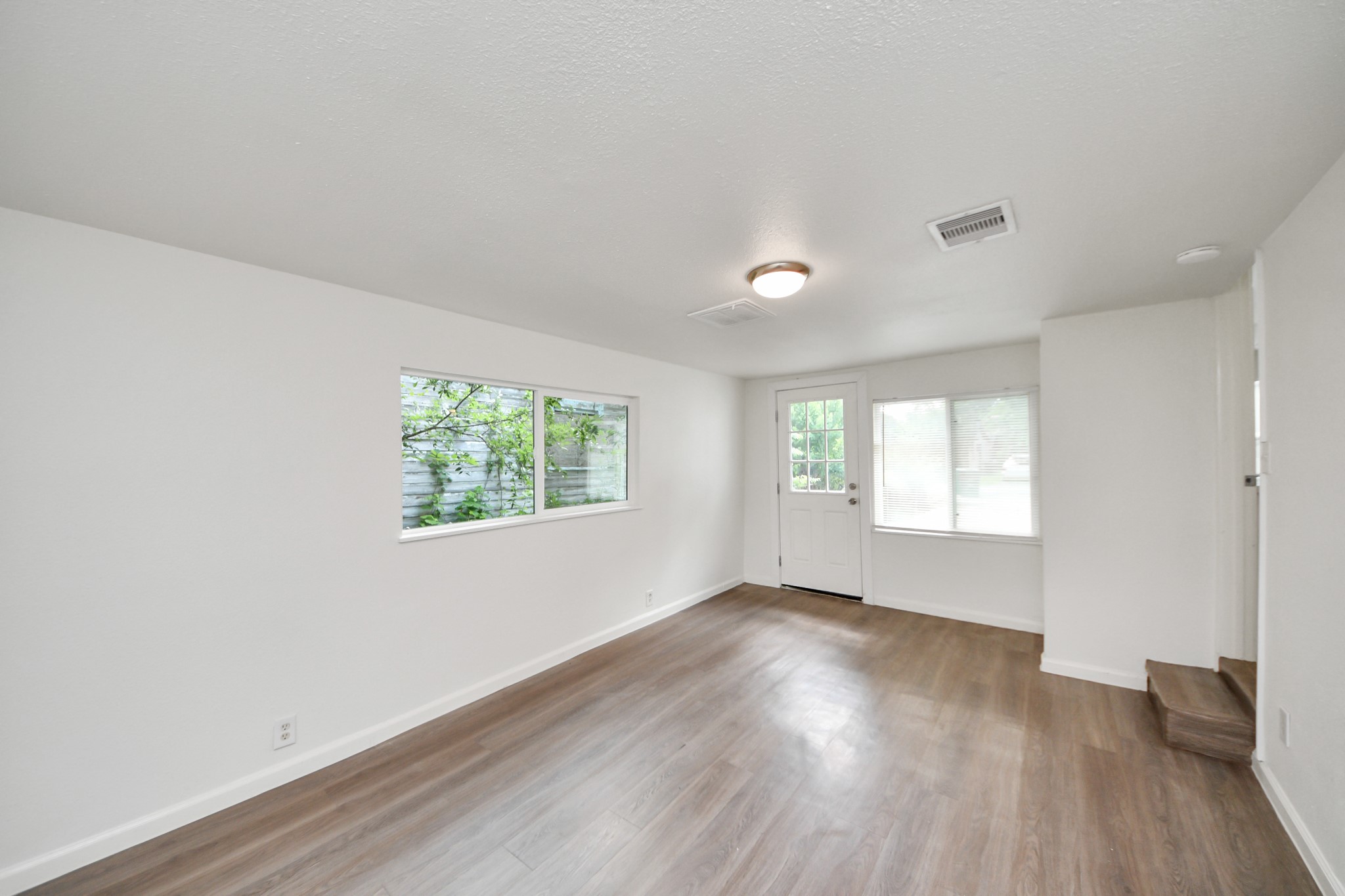 7004 Conley Street Houston, TX 77021 - Photo 10 of 32 an empty room with wooden floor and windows