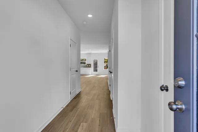 a view of a kitchen with a sink and dishwasher a refrigerator with wooden floor