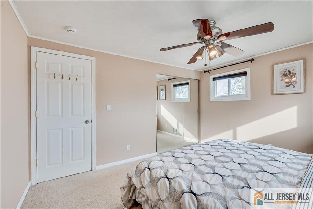 19 Oxford Road East Brunswick, NJ 08816 - Photo 19 of 41 a bedroom with a large bed and a chandelier