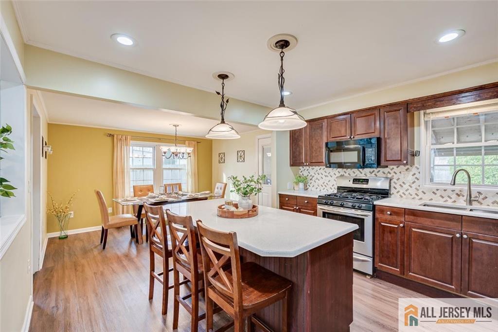 19 Oxford Road East Brunswick, NJ 08816 - Photo 8 of 41 a view of a dining room and livingroom with furniture wooden floor a chandelier