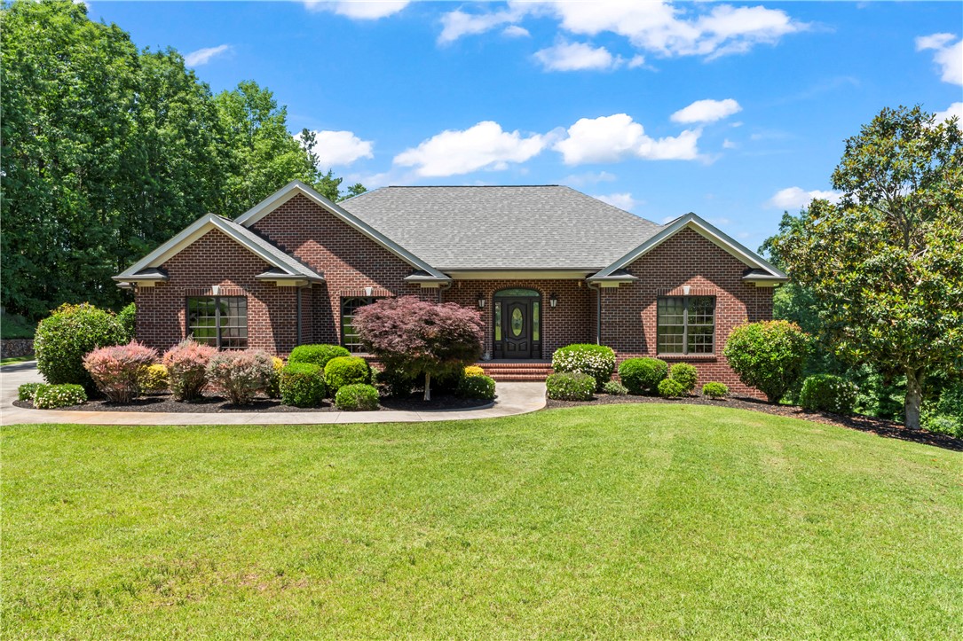 Brick facade and manicured landscaping create an inviting entrance to this charming residence.