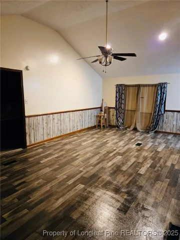 a view of a room with wooden floor and ceiling fan