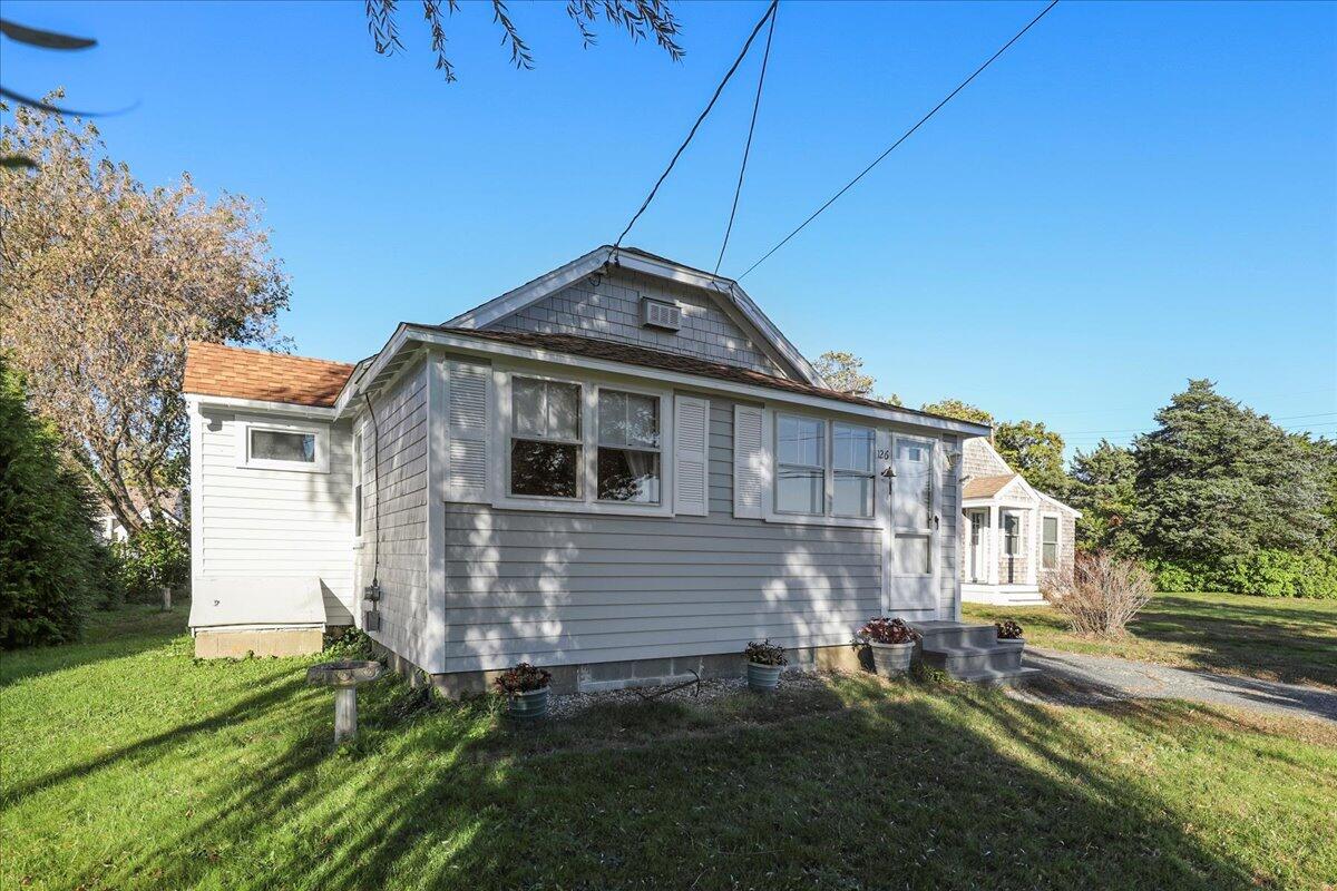 126 Commerce Road Barnstable, MA 02630 - Photo 5 of 30 a front view of a house with a yard