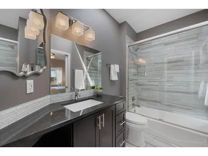 a bathroom with a sink a toilet a mirror and shower