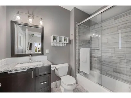 a bathroom with a granite countertop sink toilet and shower