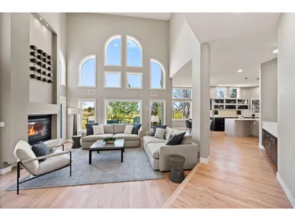 a living room with furniture fireplace and a large window