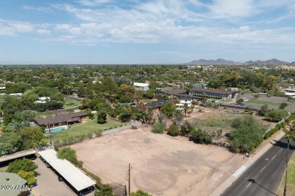 an aerial view of residential houses with outdoor space and trees