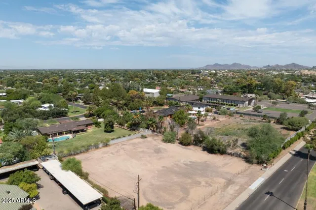 an aerial view of residential houses with outdoor space and trees