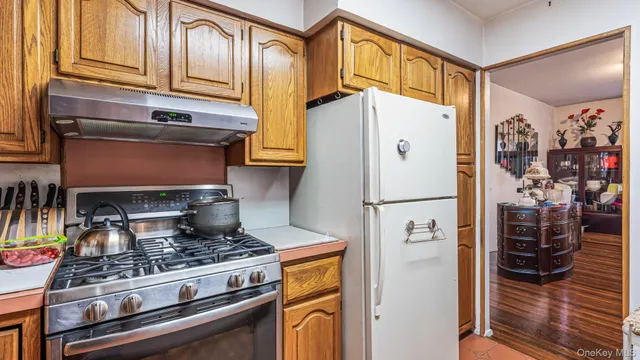 a kitchen with stainless steel appliances granite countertop a refrigerator and a stove