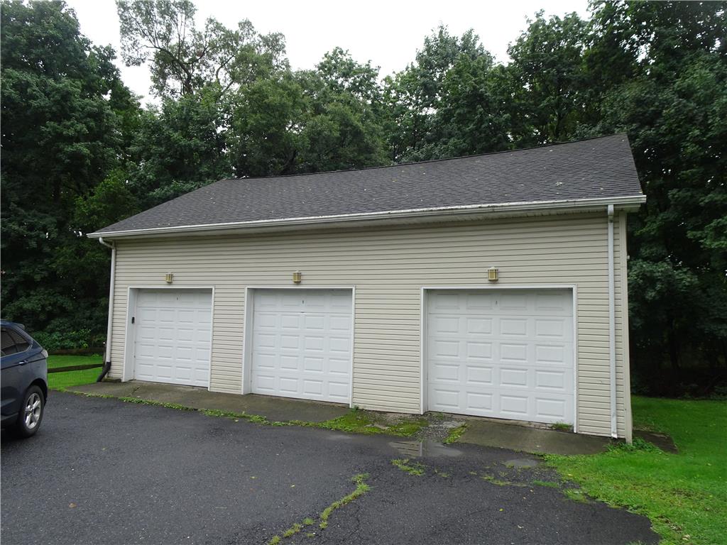 4435 Steuben Road Bethlehem, PA 18020 - Photo 37 of 43 A spacious three-car garage provides ample parking and storage, nestled against a backdrop of mature trees.