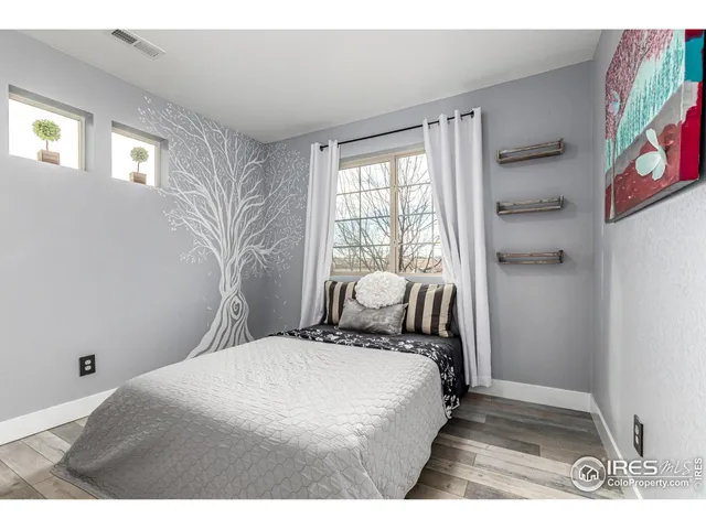 a living room with a couch piano table and a clock on the wall