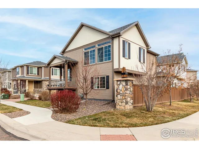 a view of a white house with large windows next to a road