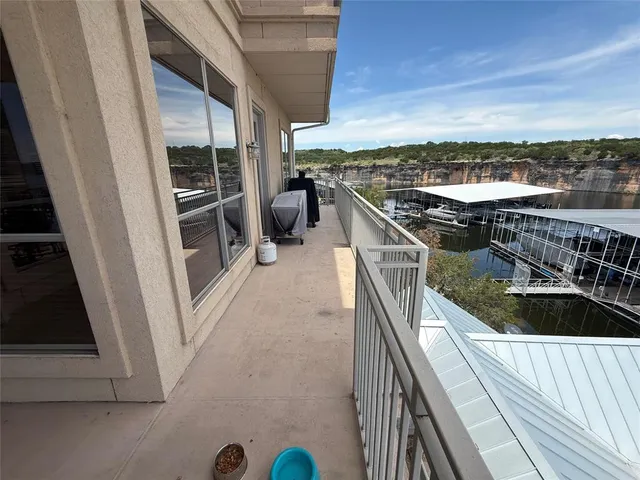 a kitchen with stainless steel appliances granite countertop a refrigerator a stove and a dining table with wooden floor