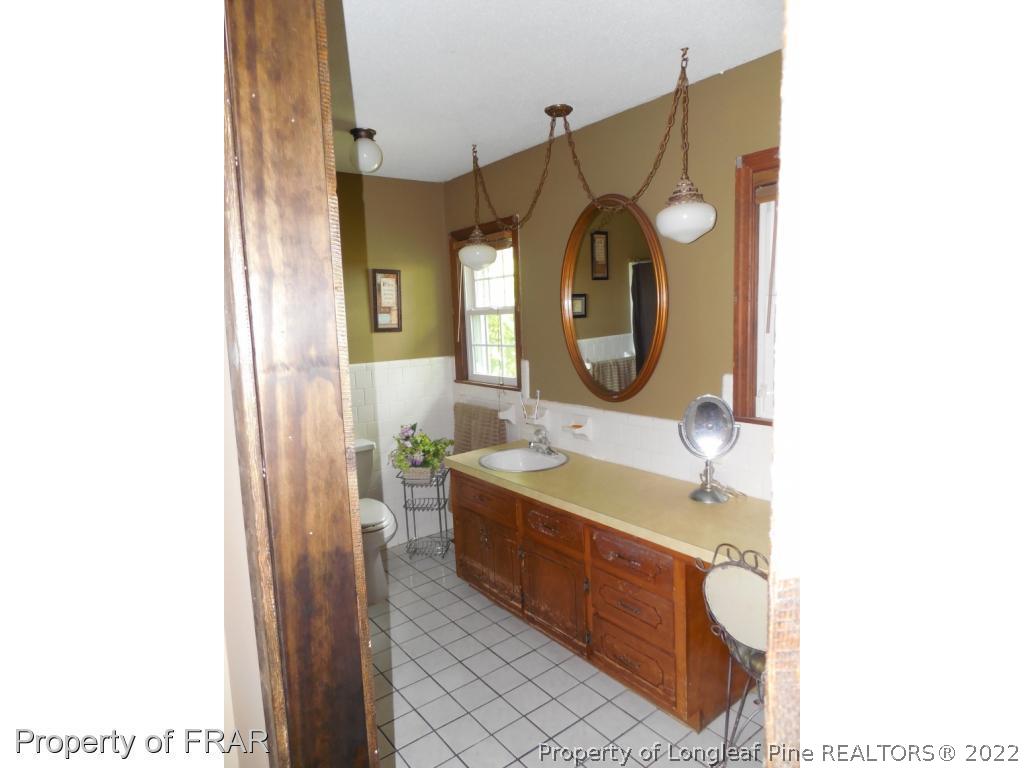5765 Stewart Road Wade, NC 28395 - Photo 15 of 22 a bathroom with a sink and a mirror