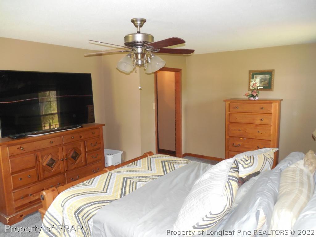 5765 Stewart Road Wade, NC 28395 - Photo 19 of 22 a bedroom with a bed and a flat screen tv