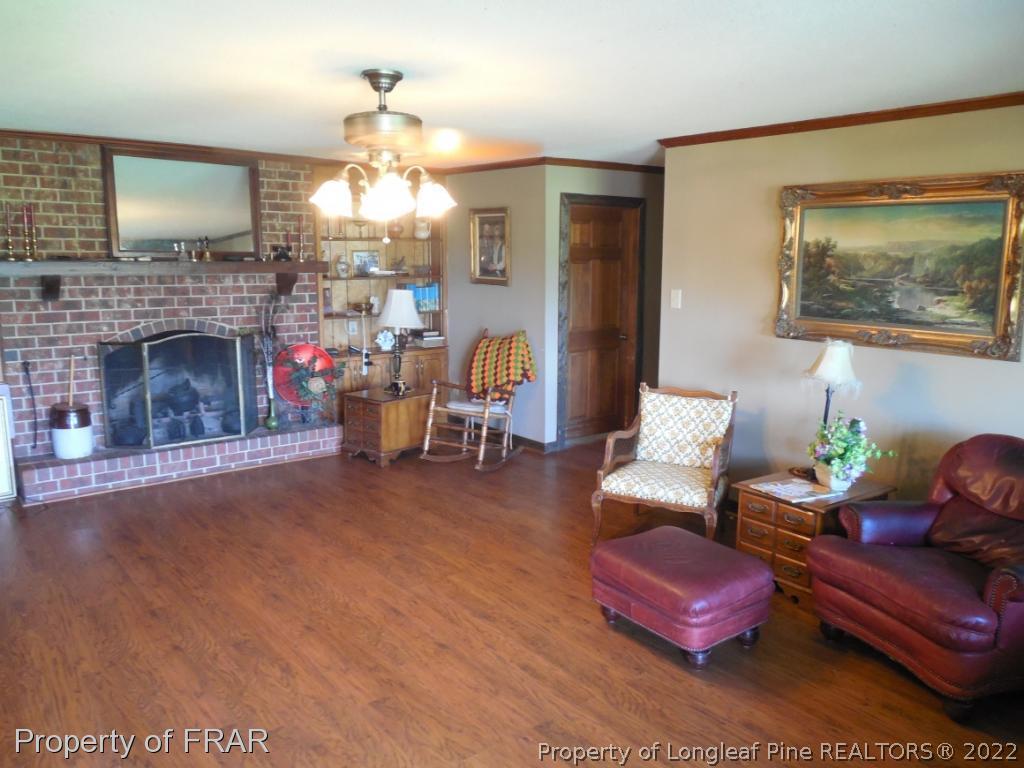 5765 Stewart Road Wade, NC 28395 - Photo 3 of 22 a living room with furniture and a fireplace
