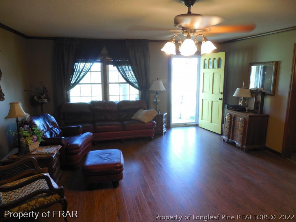 5765 Stewart Road Wade, NC 28395 - Photo 4 of 22 a living room with furniture and a chandelier