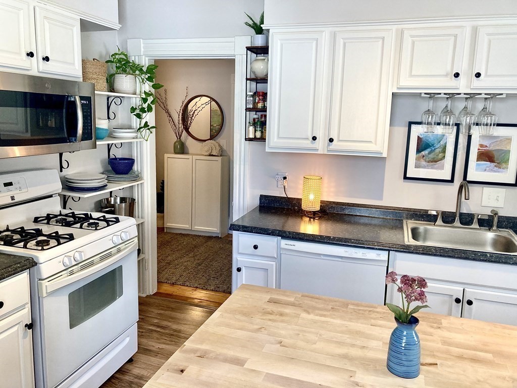 946 Bay Road, Unit 3 Hamilton, MA 01982 - Photo 1 of 13 a kitchen with granite countertop a stove a sink and a microwave