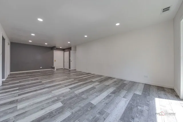 a view of an empty room with wooden floor