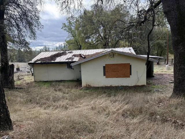 a backyard of a house with table and chairs