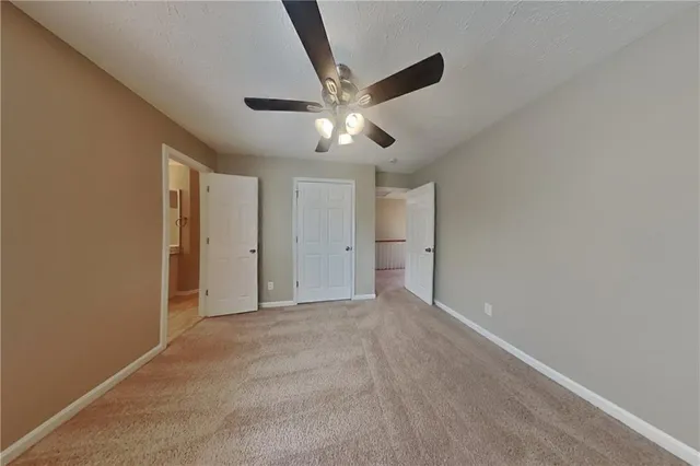 a view of an empty room and chandelier fan