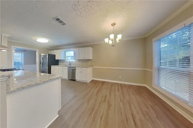 a view of a kitchen with cabinets and wooden floor