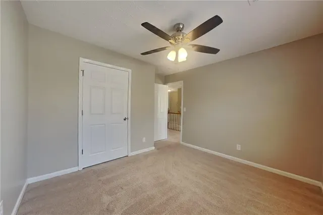 an empty room with a ceiling fan and a window