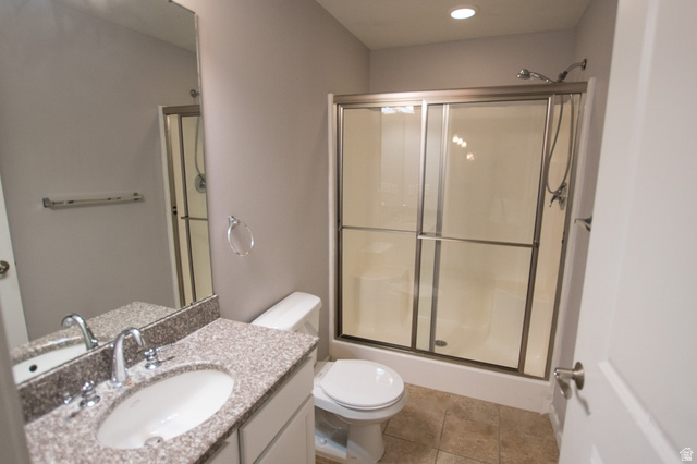 2150 South Main Street, Unit R405 Salt Lake City, UT 84115 - Photo 13 of 20 Bathroom featuring a vanity with an undermount sink, a speckled countertop, and a large wall mirror