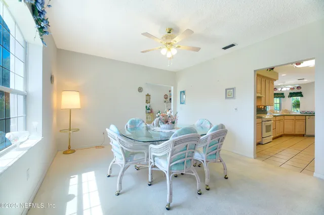 a large white kitchen with granite countertop a large window and a counter top space
