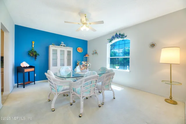 a dining hall with stainless steel appliances granite countertop a refrigerator and a sink