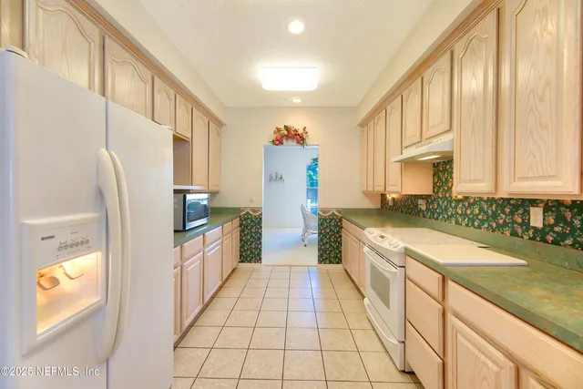 a spacious bedroom with a bed a chandelier and a window