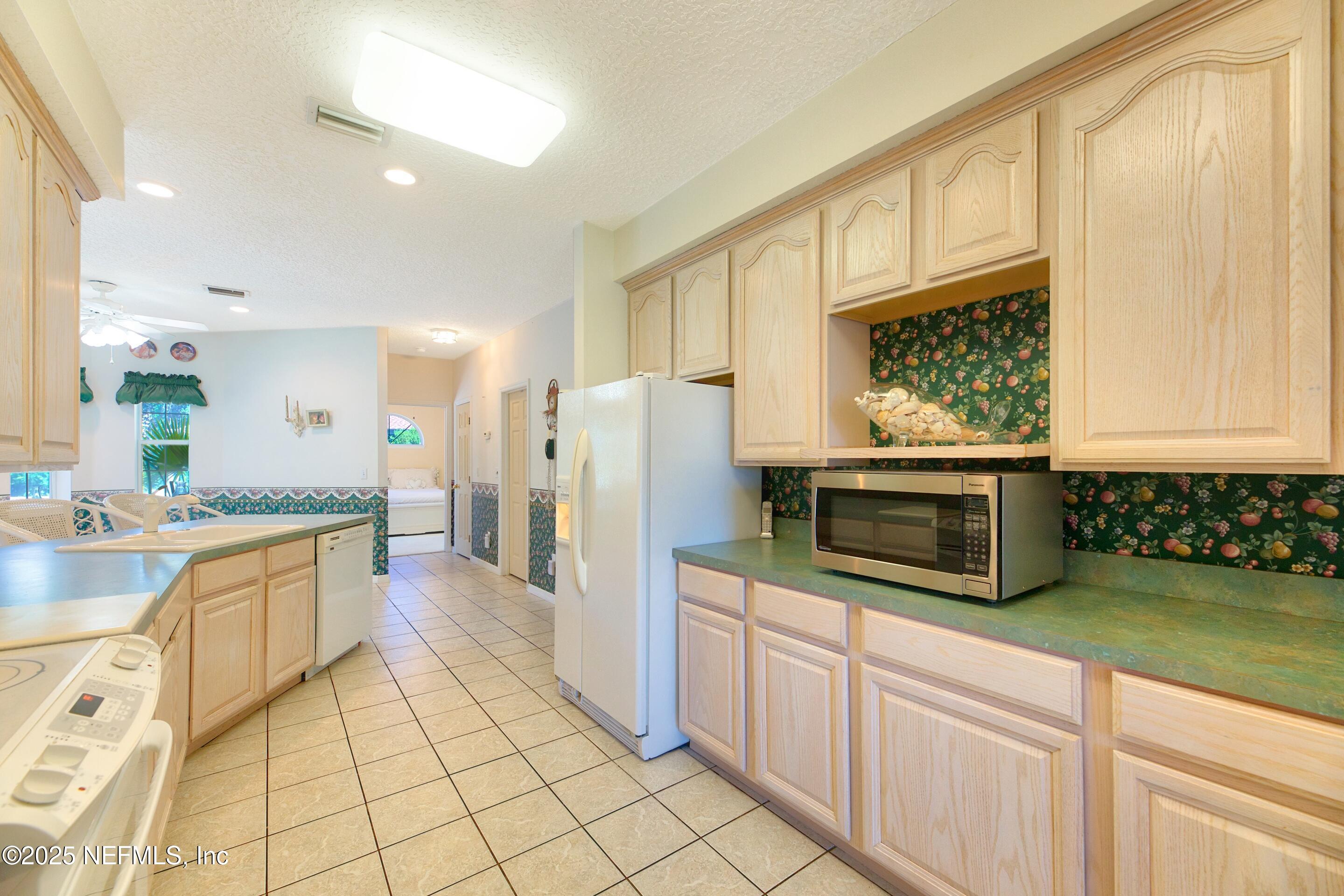 430 Marsh Point Circle St. Augustine, FL 32080 - Photo 24 of 69 a kitchen with stainless steel appliances a stove a sink and a microwave