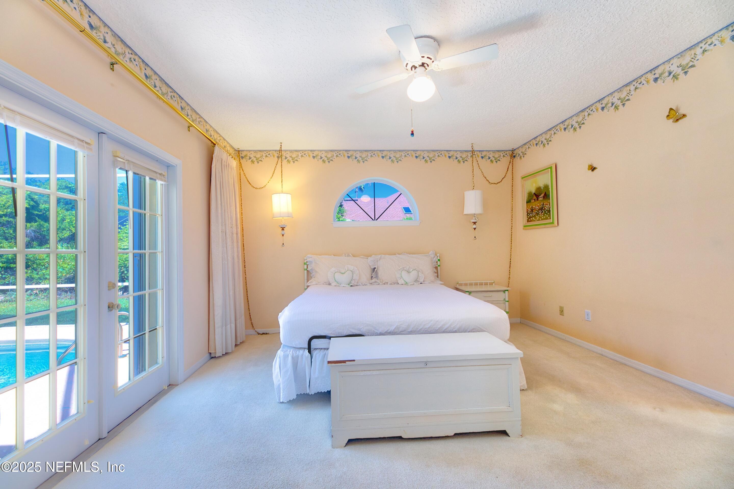 430 Marsh Point Circle St. Augustine, FL 32080 - Photo 28 of 69 a spacious bedroom with a bed and a chandelier