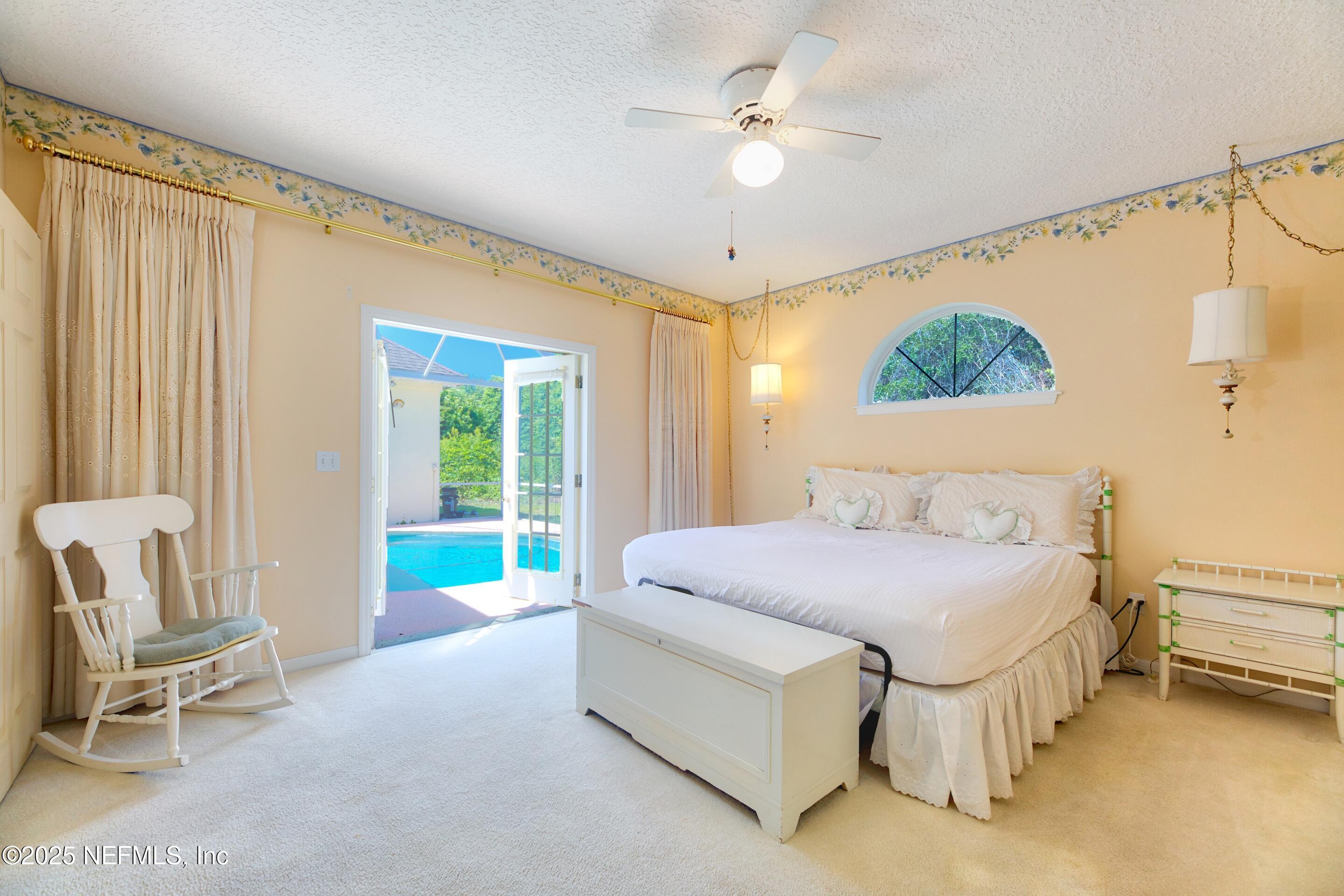 430 Marsh Point Circle St. Augustine, FL 32080 - Photo 29 of 69 a spacious bedroom with a bed a chandelier and a window