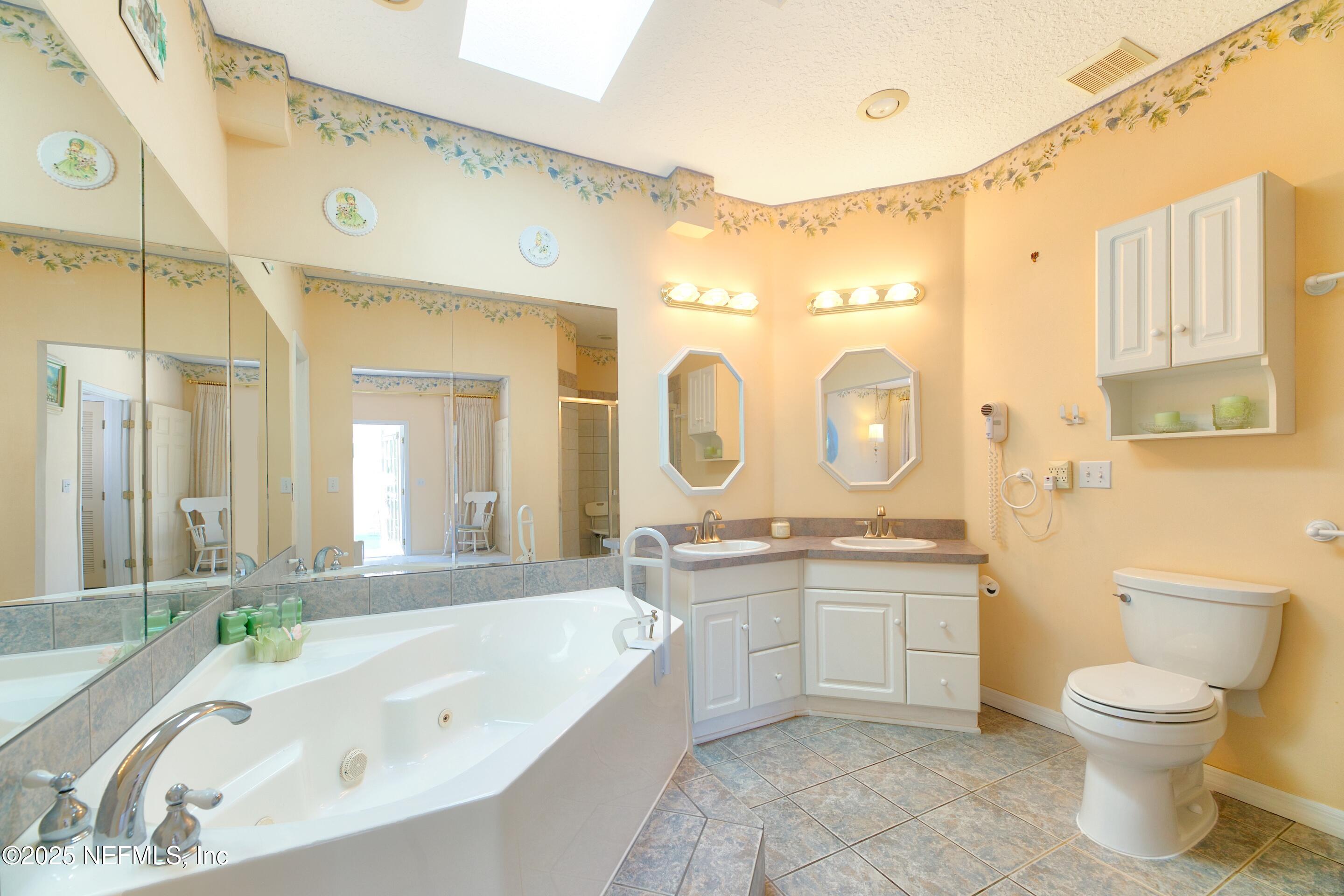 430 Marsh Point Circle St. Augustine, FL 32080 - Photo 30 of 69 a spacious bathroom with a granite countertop sink a toilet a mirror a bathtub and shower